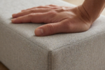 Hand pressing a firm wedge massage bolster to show high-density foam support