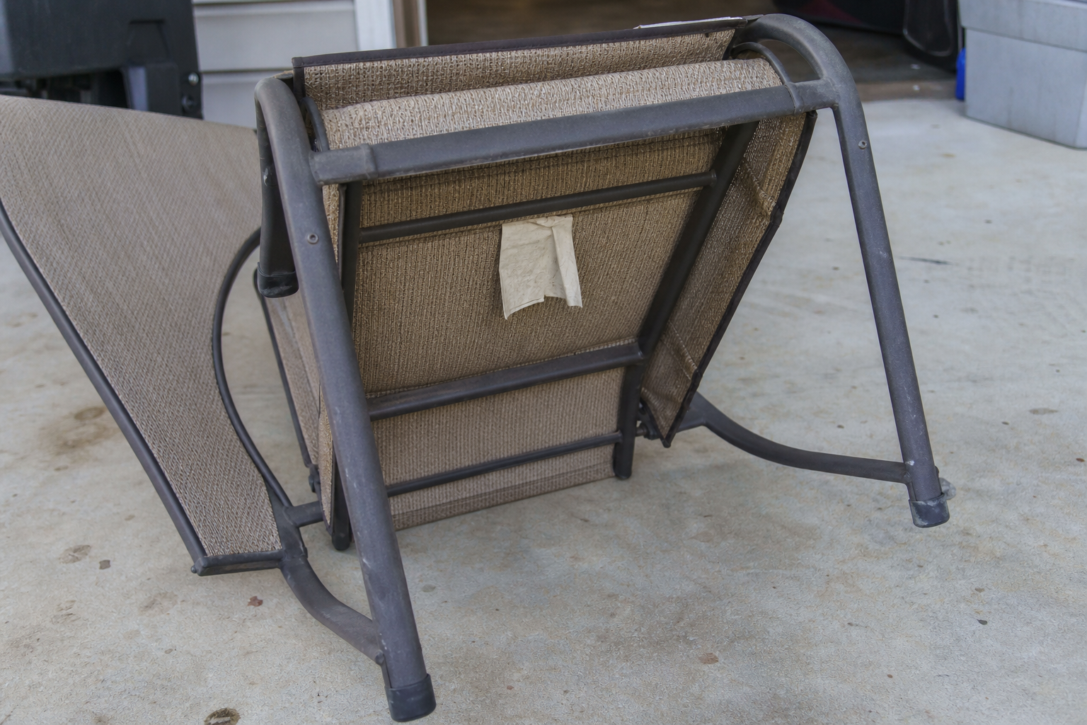 Wicker Hampton Bay Barclay dining chair with the white model label exposed under the seat frame