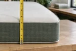 Custom mattress topper edge close-up - uniform thickness, clean factory cut, and a measuring tape
