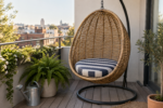 A hanging egg chair with a custom round cushion on a small city apartment balcony with potted plants