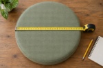 Measuring an egg chair cushion diameter - a tape stretched across the round pad at its widest point