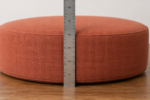 Measuring egg chair cushion thickness - a steel rule standing against the side of a thick round pad to read the four inch depth