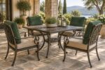 Cast aluminum outdoor dining set with scroll details and firm replacement cushions in sand and green