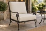 Black wrought iron patio lounge chair with scroll arms fitted with new ivory replacement cushions
